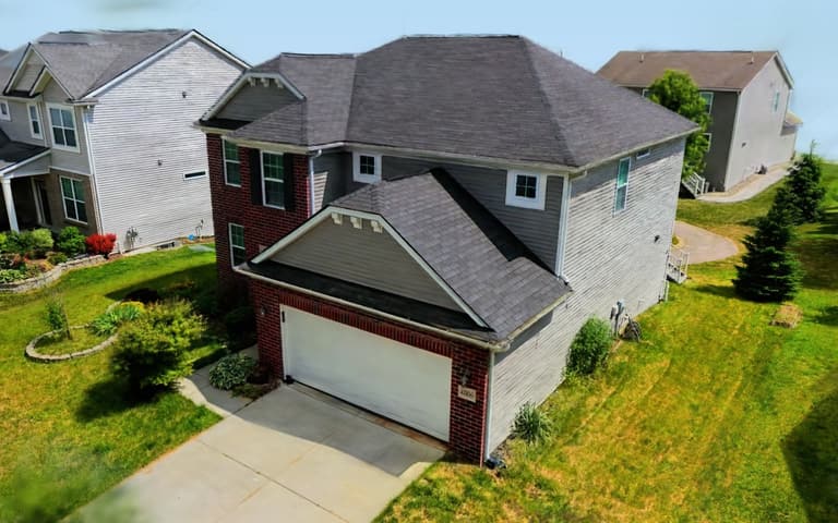 Live 3D model of a two-storey brick and siding home, its driveway, lawn and neighbouring houses
